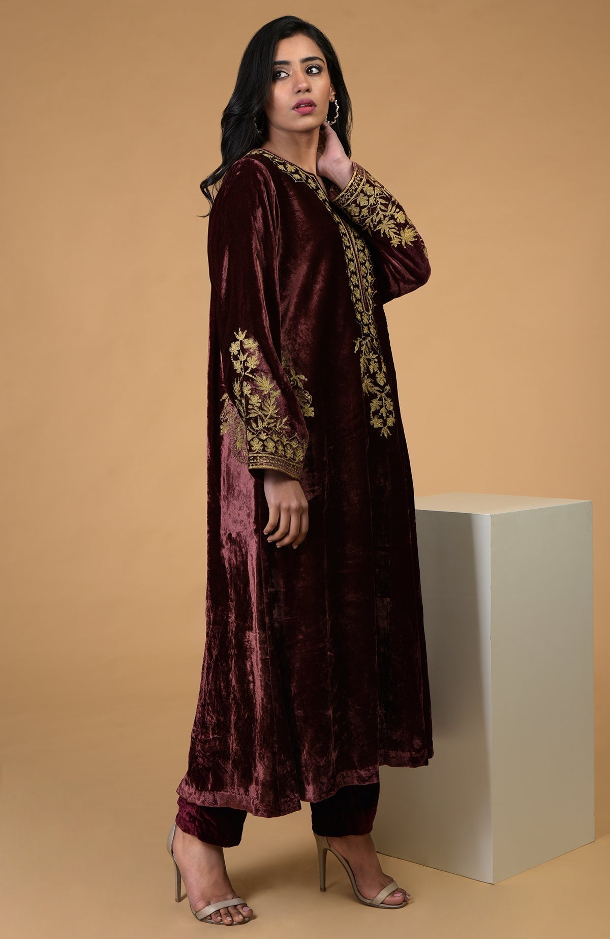A woman models a rusty rose Kashmiri tilla aari embroidered choga kurta set.