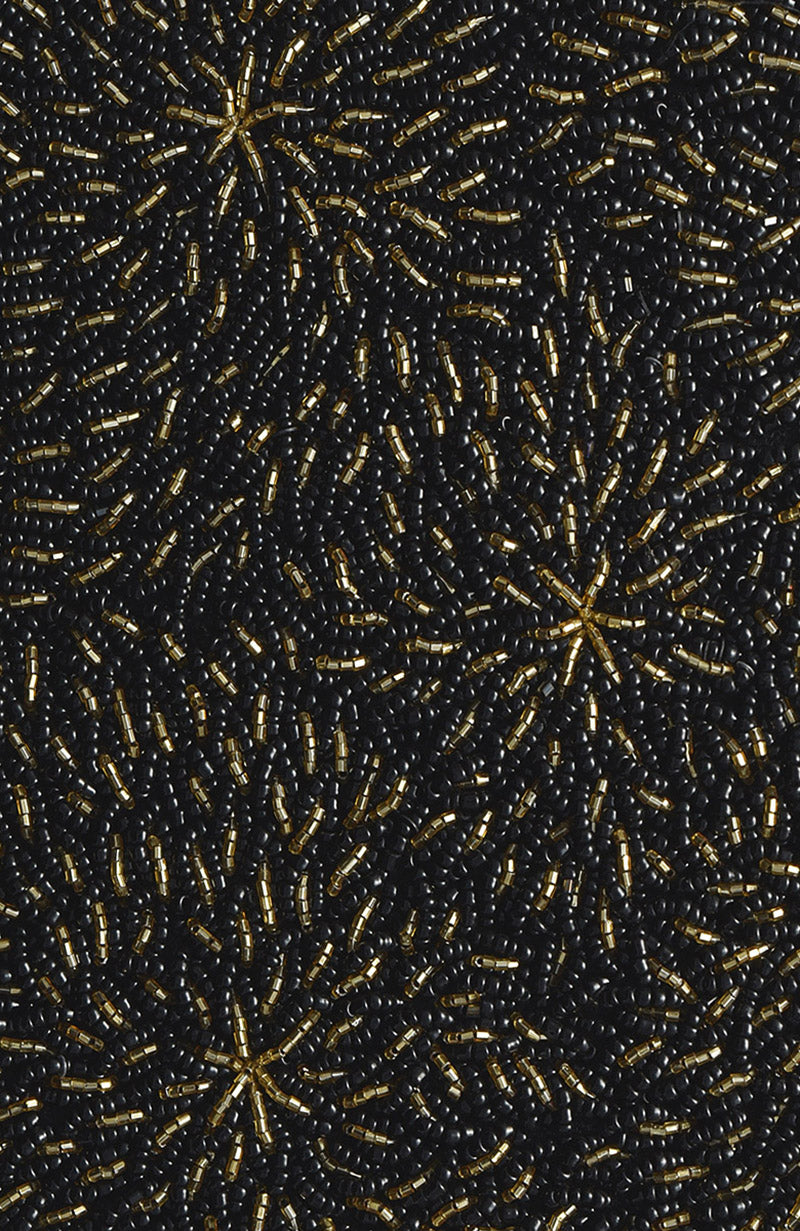 Black and gold hand-embroidered blouse with a starburst bead pattern.