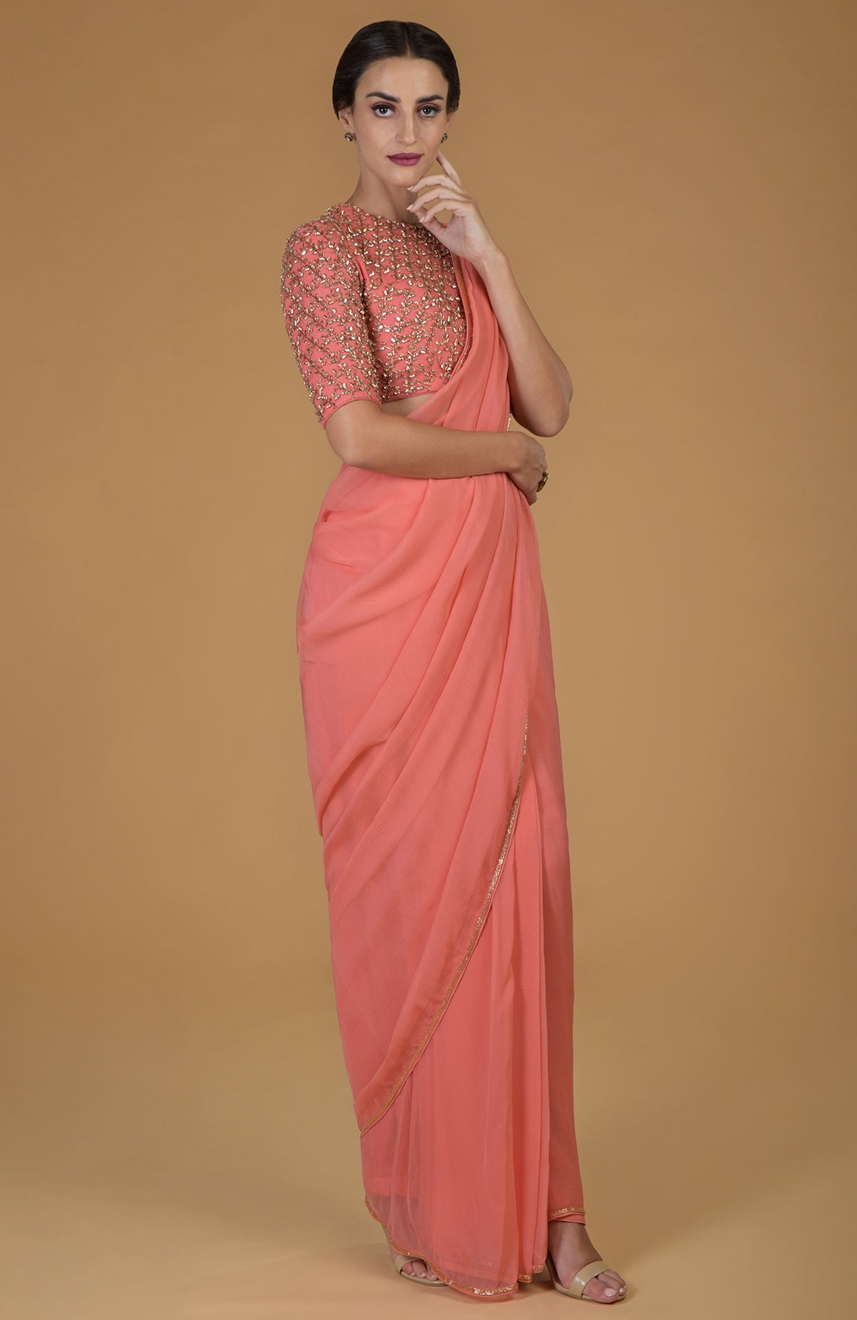 Salmon chiffon saree with a hand-embroidered blouse featuring beads and crystals.