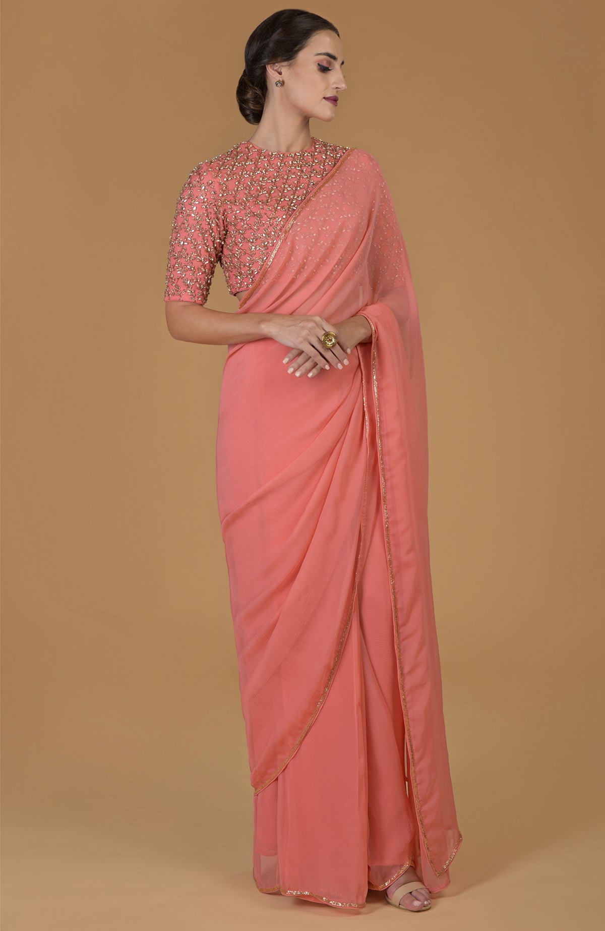 Salmon chiffon saree with a hand-embroidered blouse featuring beads and crystals.