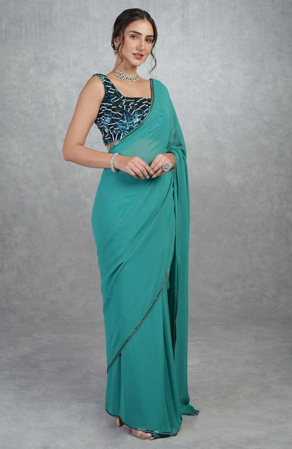 Blue georgette silk saree with a hand-embroidered, sequined blouse.