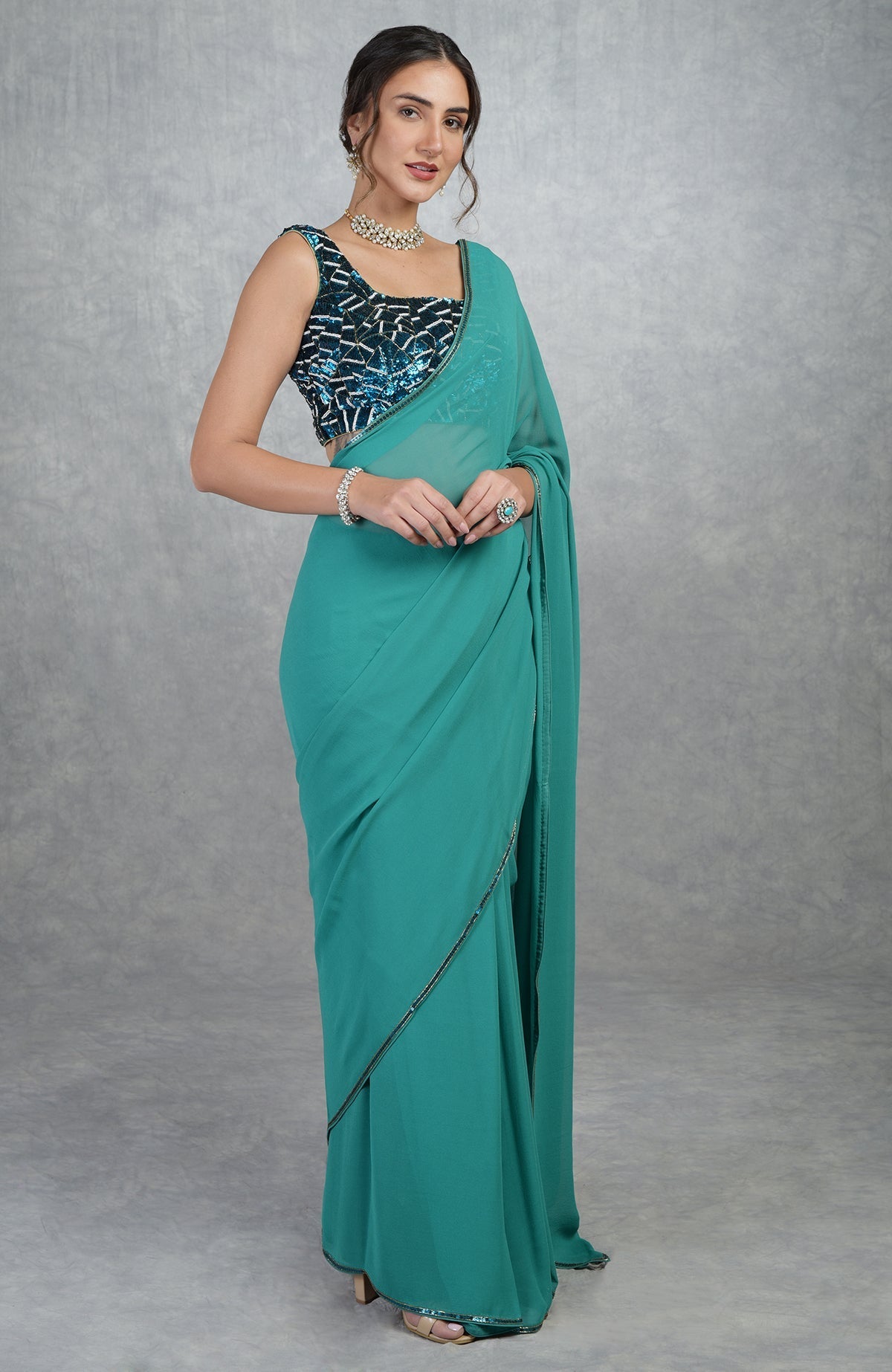 Blue georgette silk saree with a hand-embroidered, sequined blouse.