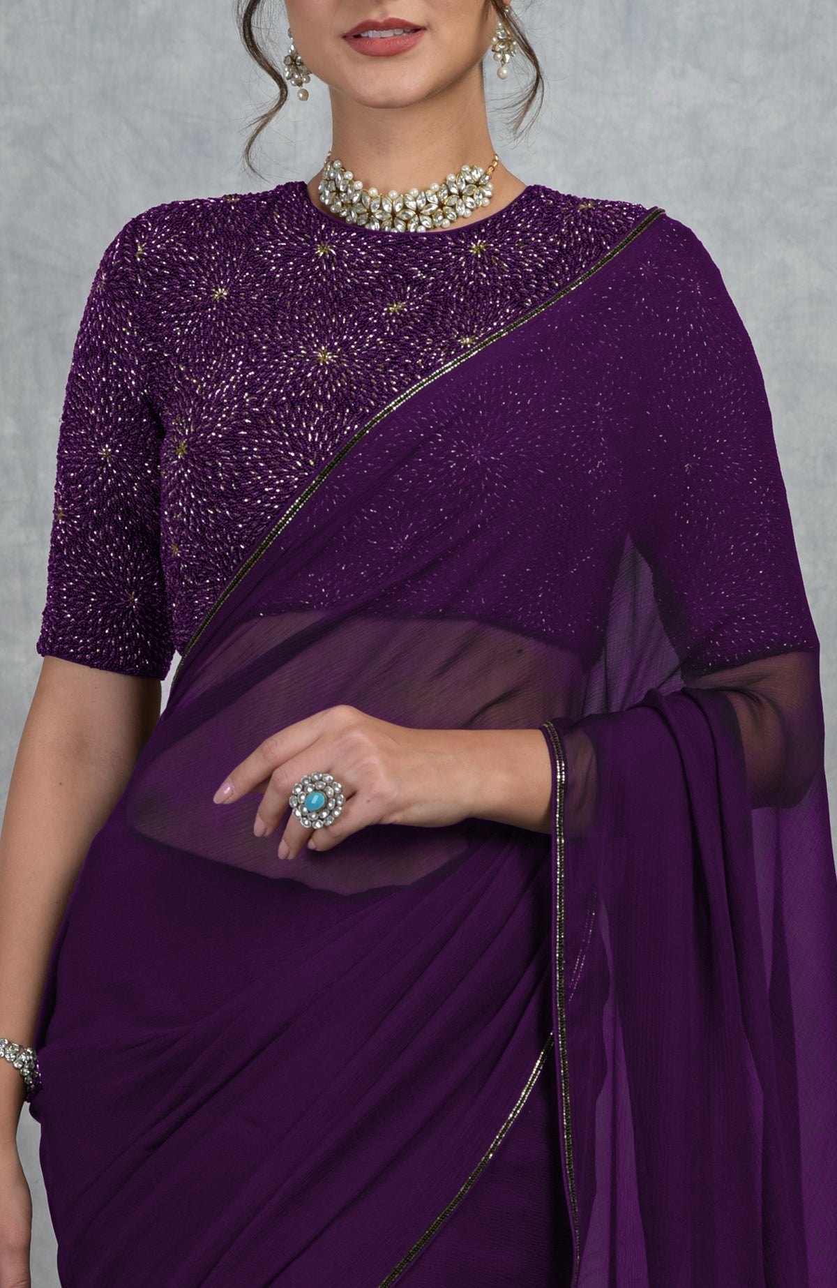 Plum purple chiffon saree with a gold hand-embroidered blouse.