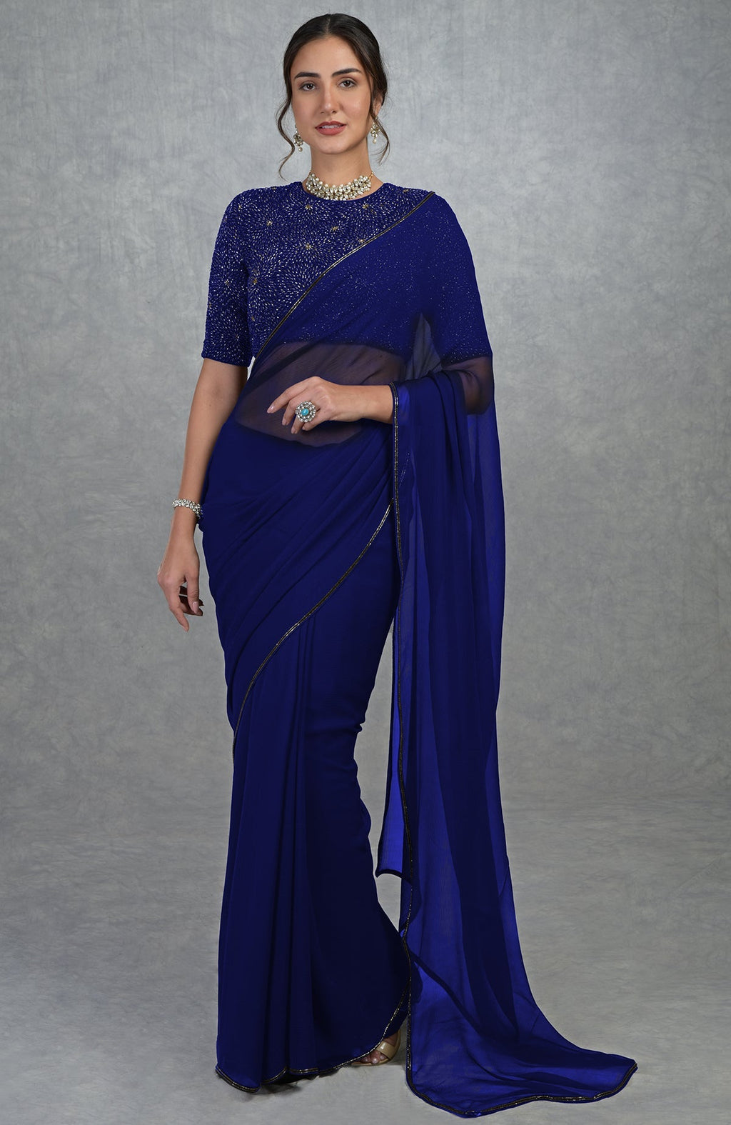 Royal blue chiffon saree with a hand-embroidered blouse and slim borders.