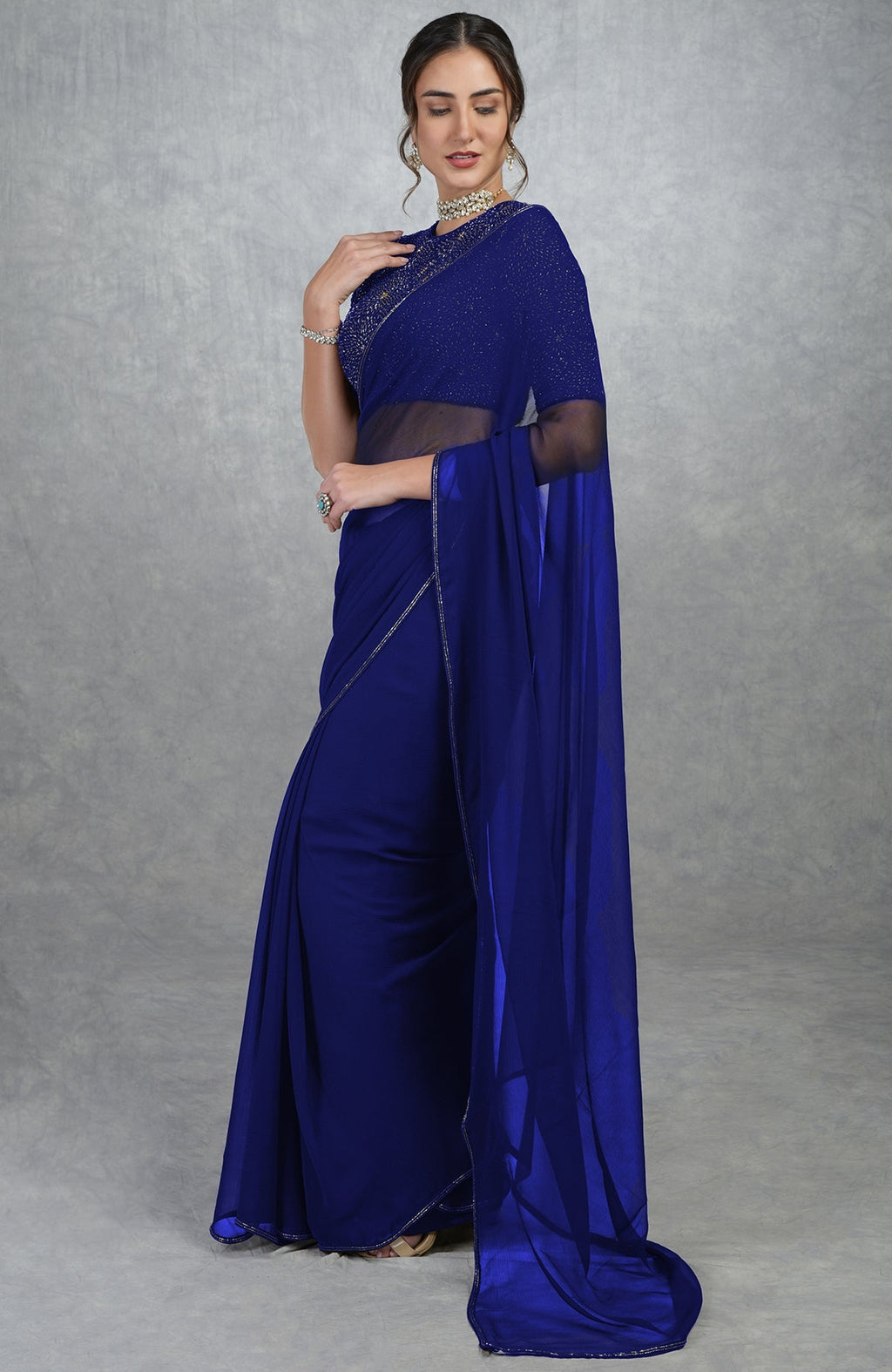 Royal blue chiffon saree with gold hand-embroidered blouse.
