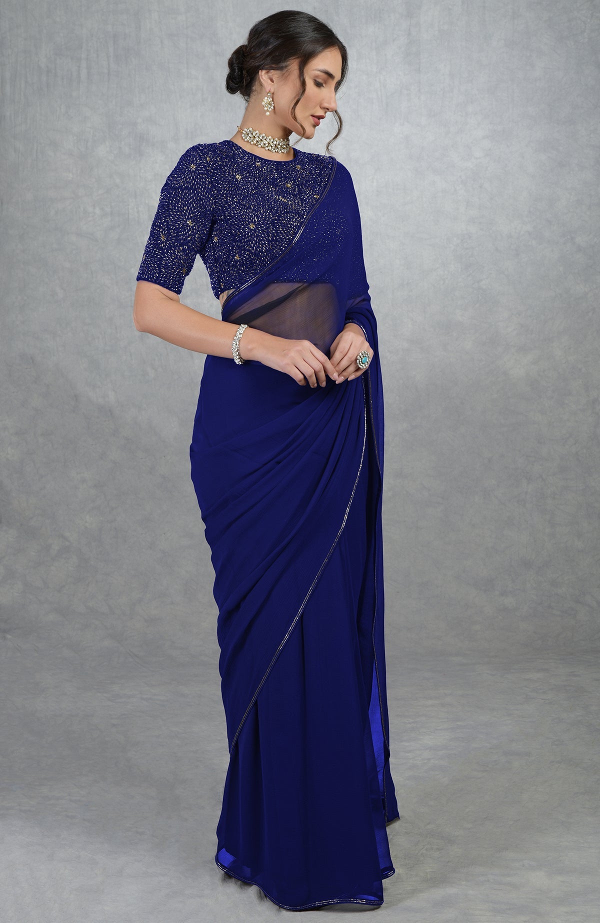 A woman models a black gold hand-embroidered saree and blouse.