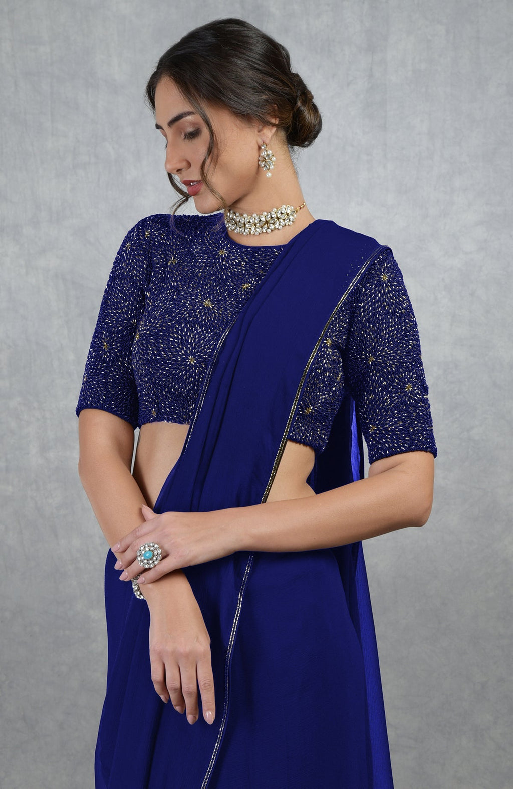 Royal blue chiffon saree with a gold hand-embroidered blouse.