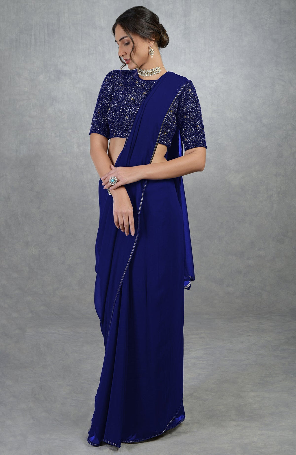 Royal blue chiffon saree with a gold hand-embroidered blouse.