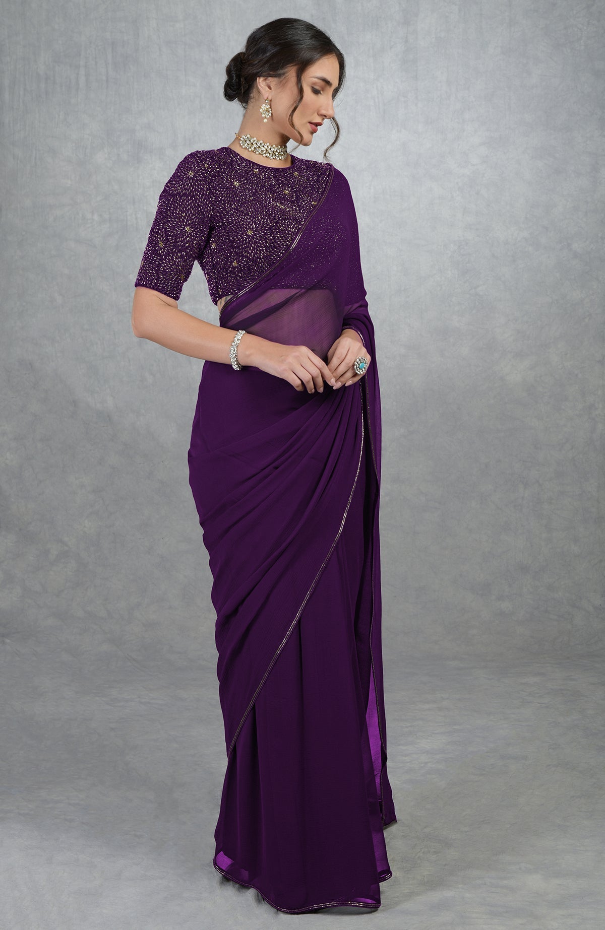 Plum purple chiffon saree with a gold hand-embroidered blouse.