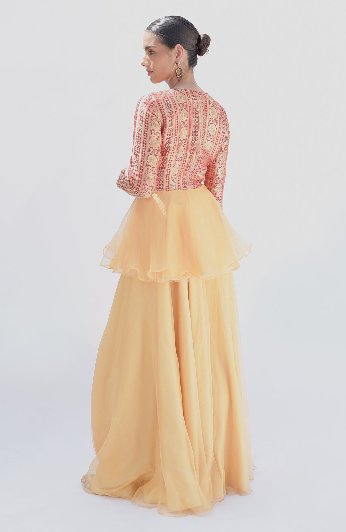 A woman models a Rangkat Banarasi handwoven peplum top and gold sharara.