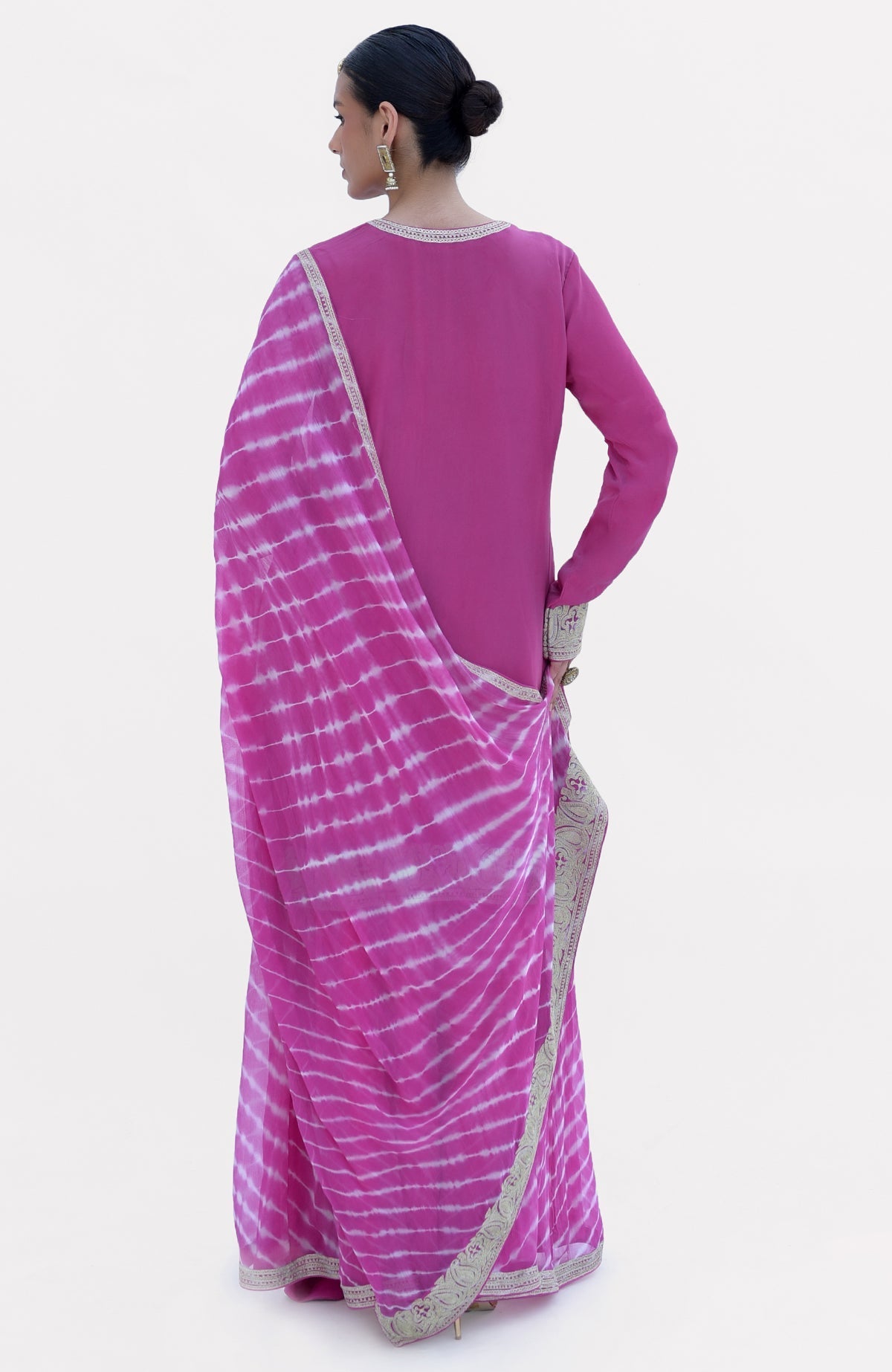 A woman models a pink Leheriya Sharara Set with a tie-dye dupatta.